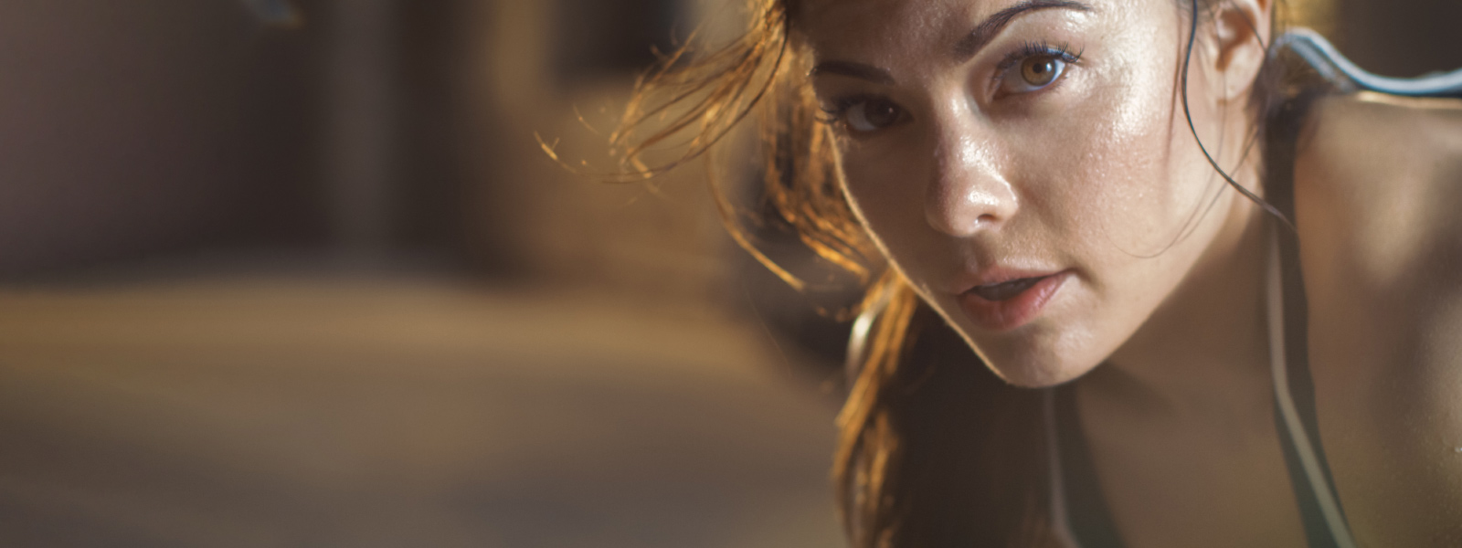 Bien épuisée grâce à l'entraînement Tabata Femme sportive, légèrement en sueur, regarde le spectateur depuis la droite