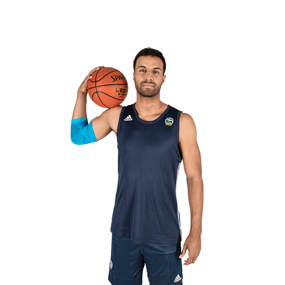 Manchette de coude lors de la pratique du basketball Homme avec un ballon de basket portant une manchette de sport pour le coude