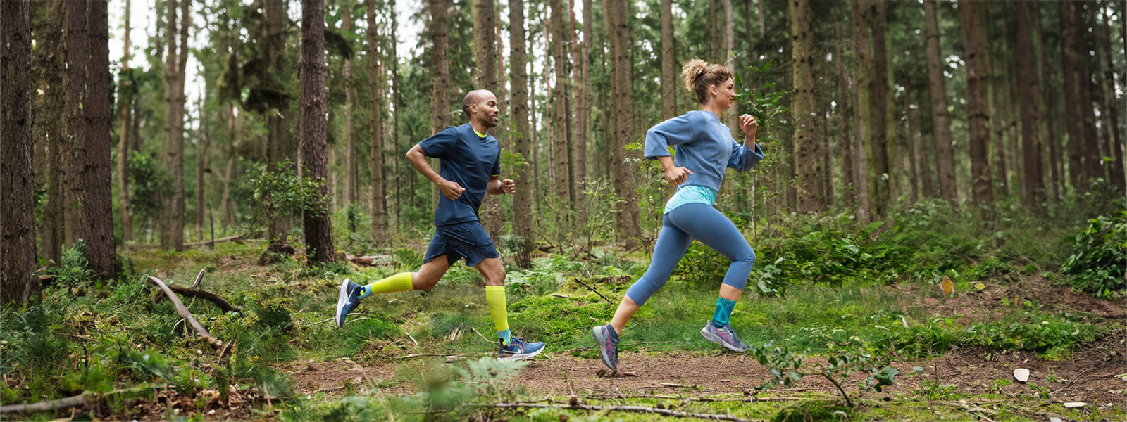Femme et homme courent à travers la forêt Une femme et un homme courent à travers une forêt dense et portent des bandages