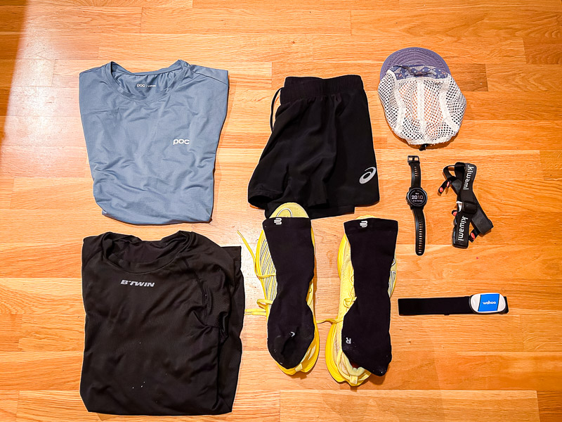 Laufkleidung und Ausrüstung für Halbmarathon - Vorbereitung auf den Renntag Halbmarathon-Vorbereitungen: Ein komplettes Laufoutfit für den Renntag liegt bereit, inklusive blauer Funktionsbekleidung, gelber Laufschuhe und technischer Ausrüstung wie Pulsuhr und Herzfrequenzmesser.