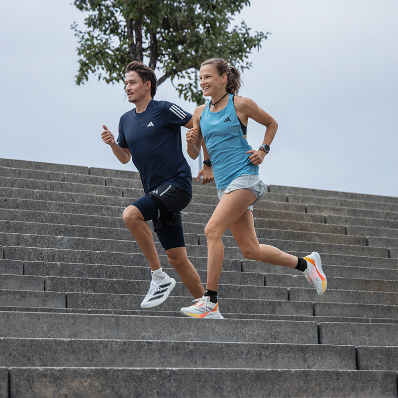 L'entraînement de course n'est pas toujours une partie de plaisir, mais en groupe, c'est d'autant plus motivant Deux coureuses et un coureur courent le long d'une ligne de tramway dans une ville
