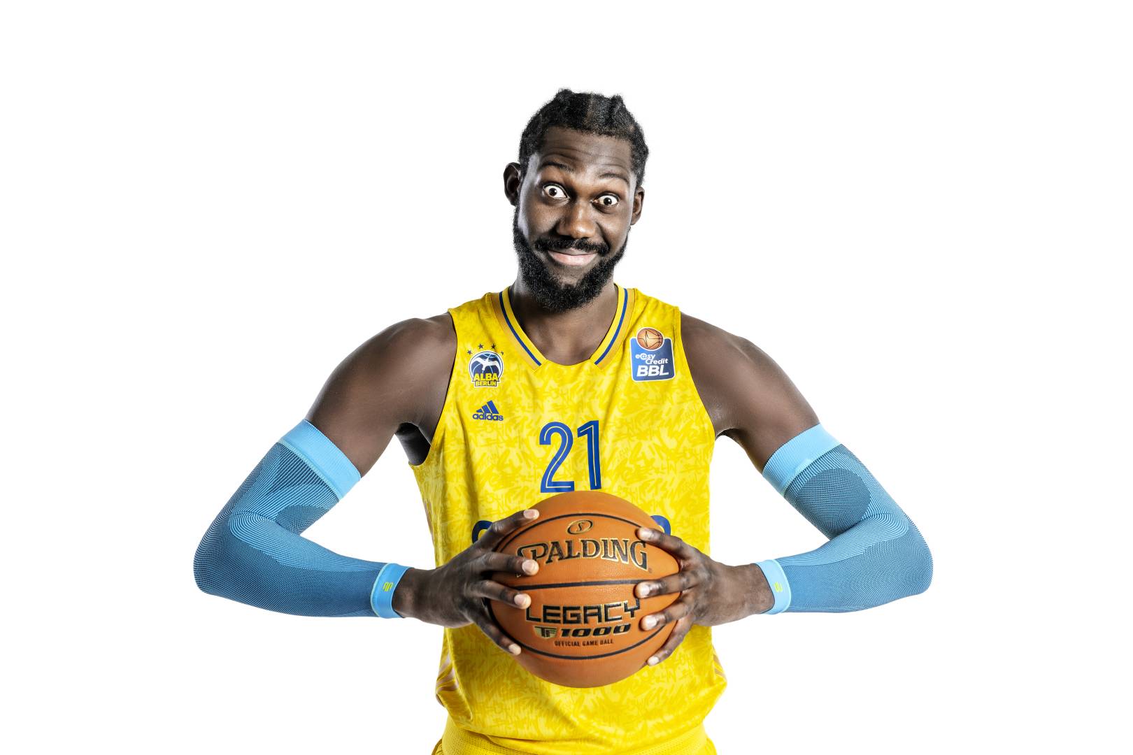 Le joueur de Alba Berlin tient le ballon de basket entre ses mains et porte une manchette de bras Le joueur de Alba Berlin tient le ballon de basket entre ses mains et porte une manchette de bras