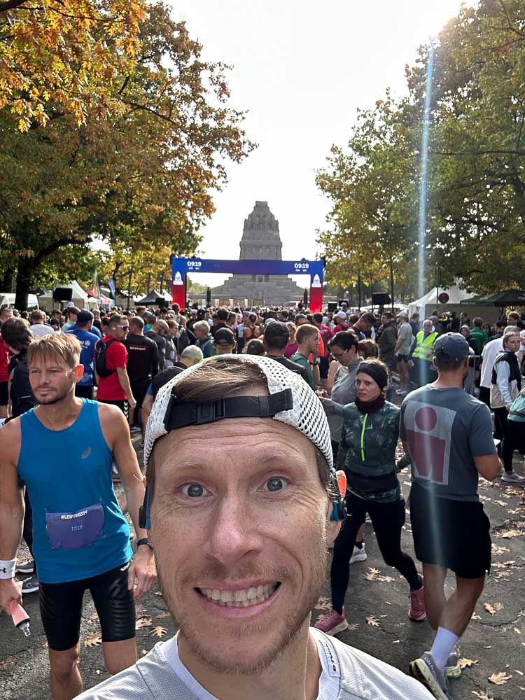 Läufer macht vor dem Start eines Halbmarathons ein Selfie im gut besuchten Startbereich