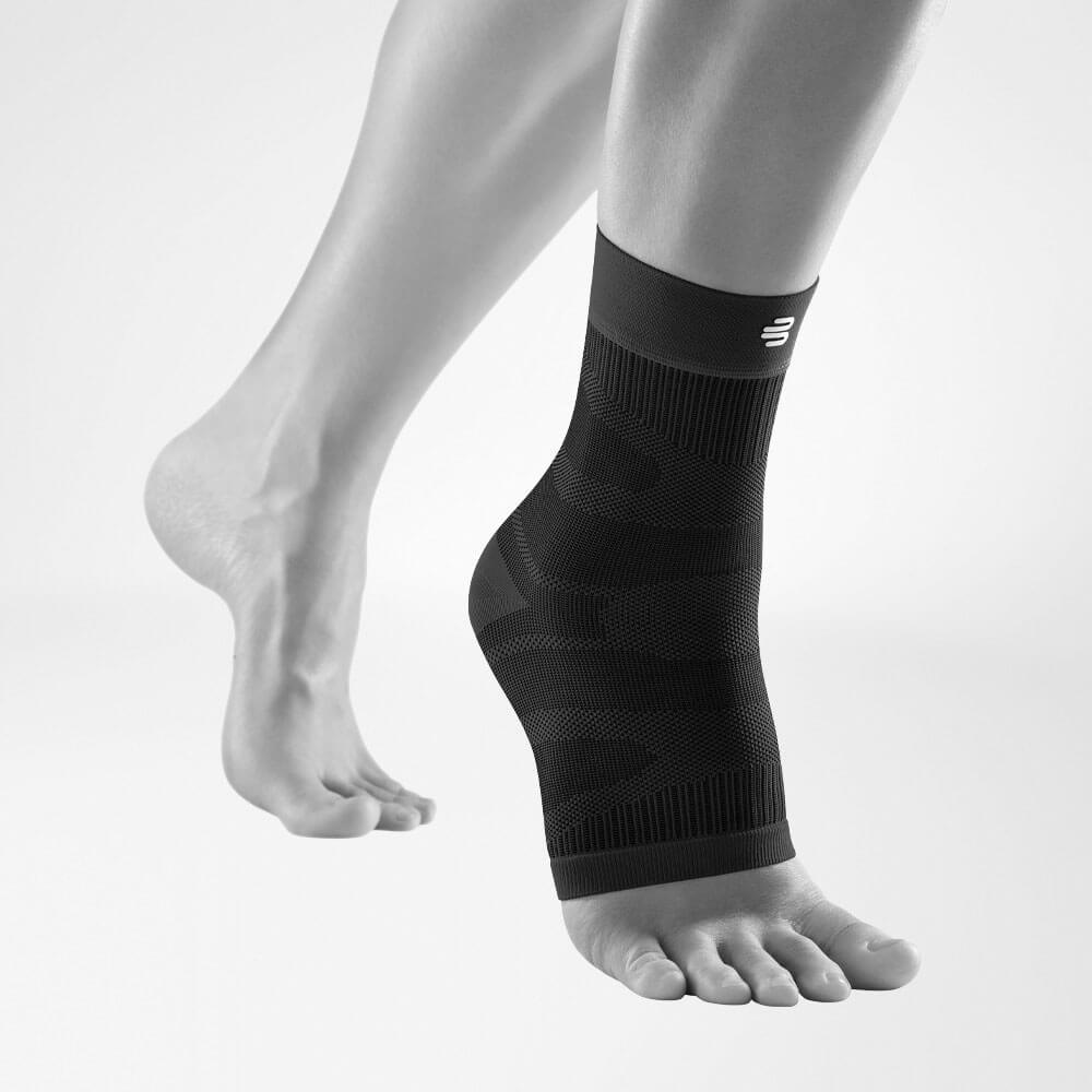Compression Ankle Support noir vue de face en biais Vue complète du Compression Ankle Support noir sur une jambe grise stylisée