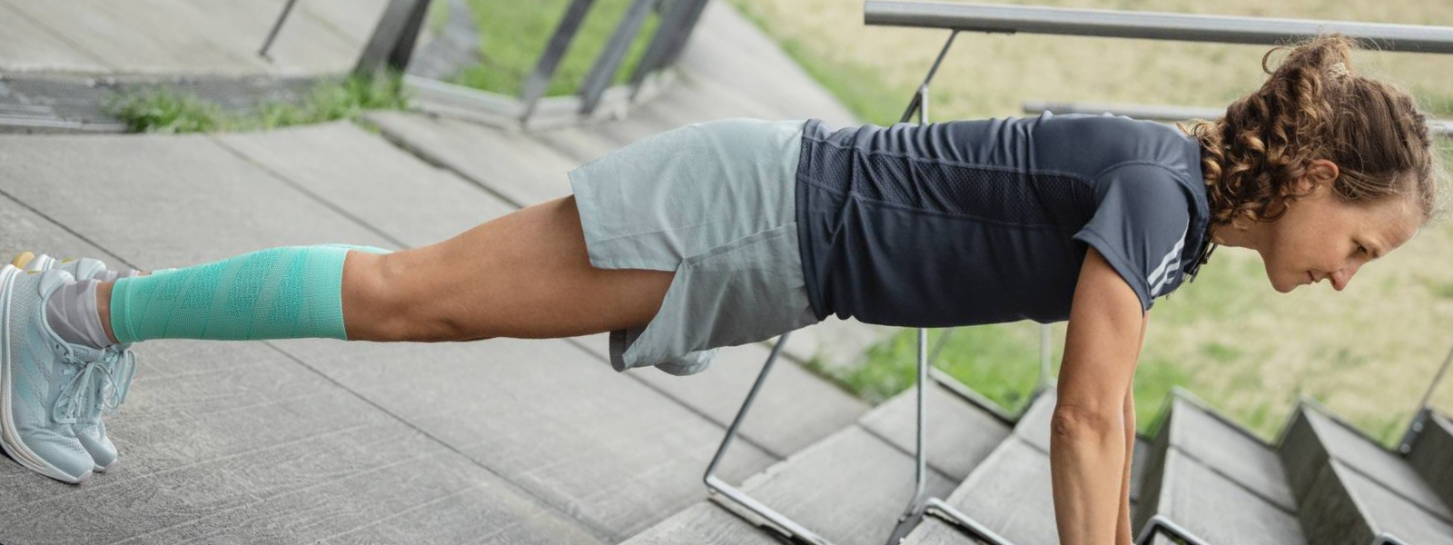 Femme fait des pompes sur un sol en béton Vue en biais par l'avant