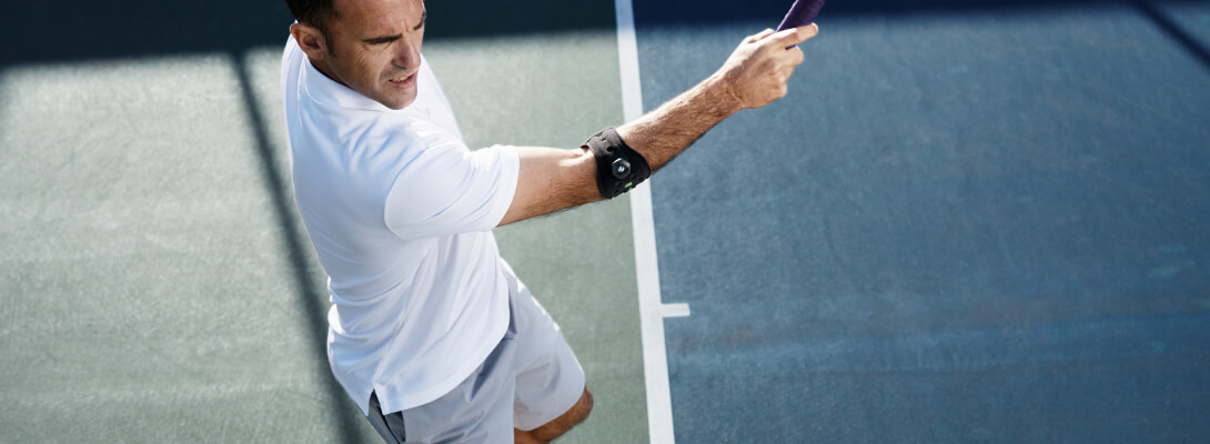 Ellenbogenbandage beim Tennis Tennisspieler der eine Ellenbogenspange zur Entlastung bei Tennisellenbogen trägt