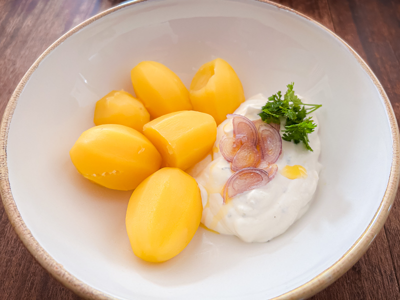 Kartoffeln mit Quark als leicht verdauliche Kohlenhydratquelle für Carbo-Loading. Ein Teller mit gekochten Kartoffeln und Quark, eine gesunde und leicht verdauliche und gesunde Mahlzeit für Carbo-Loading vor einem Halbmarathon.