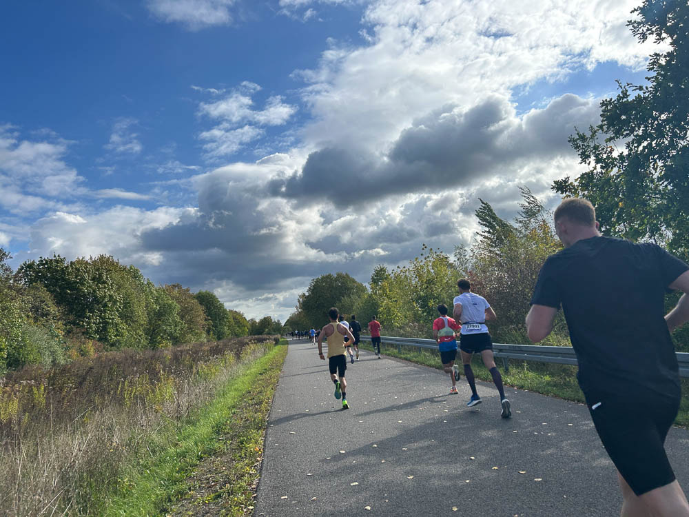 Läufer während eines Halbmarathons auf einer asphaltierten Strecke bei sonnigem Herbstwetter