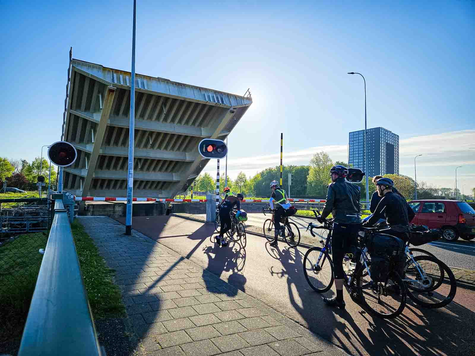 Les cyclistes d'un événement d'ultra-cyclisme attendent sur un pont levé. Différents participants du Race around the Netherlands se tiennent sur un pont levé et attendent.
