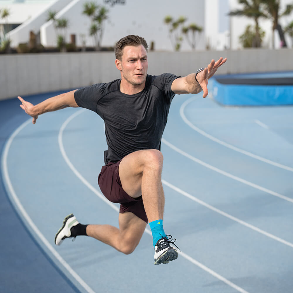 Bande de cheville lors du saut de haies Coureur avec Compression Ankle Support lors du saut de haies