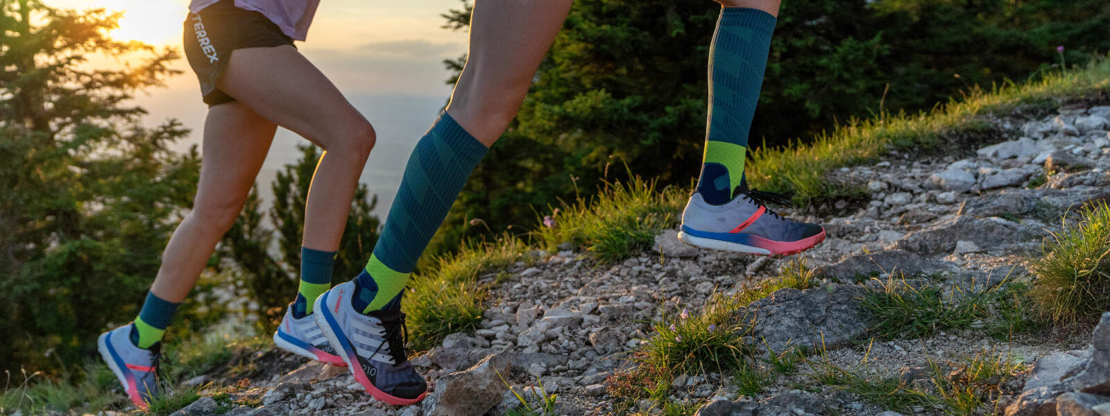 Trail Run Socks Des coureuses montent une colline en portant des Trail Run Socks