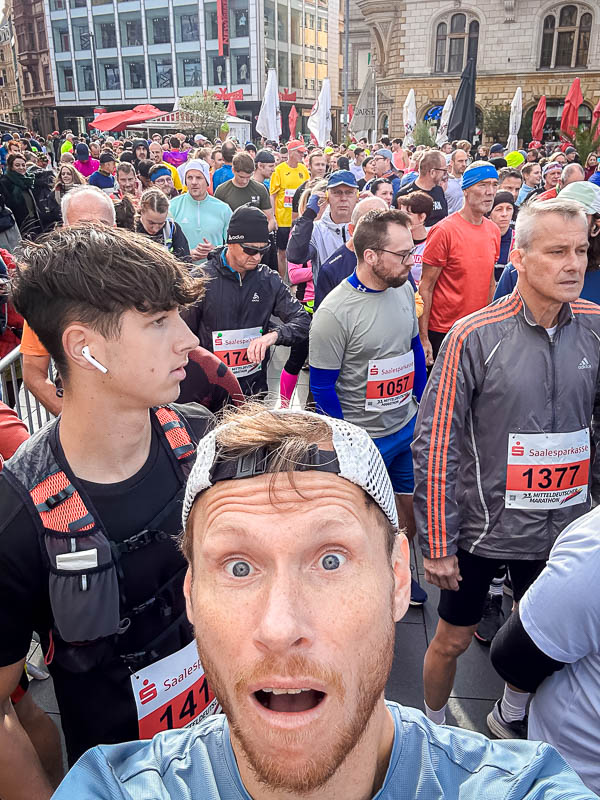 Selfie eines Teilnehmers beim Start des Mitteldeutschen Marathons 2024 in Halle Ein aufgeregter Teilnehmer macht ein Selfie direkt vor dem Start des Mitteldeutschen Marathons 2024 in Halle. Um ihn herum sind viele andere Läufer in der Menge versammelt, bereit für den Halbmarathon.