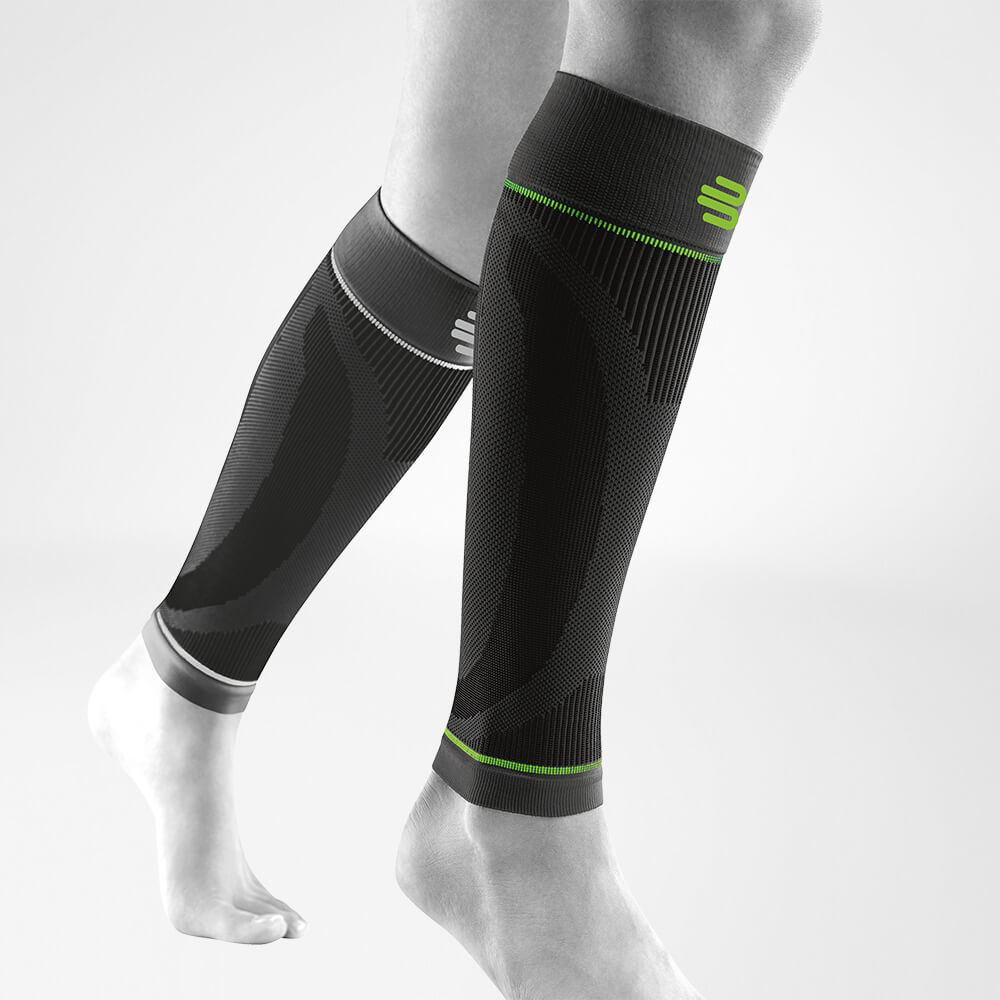 Manches pour mollets noires avant en biais Vue complète des manches de sport noires pour mollets sur une jambe grise stylisée