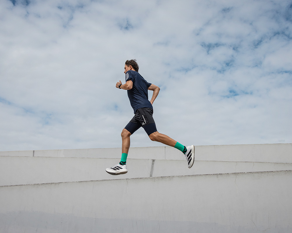 Courir au-dessus des choses : avec les Run Performance Compression Socks Perspective de contre-plongée : vue vers le haut d'un mur sur lequel un homme court avec des chaussettes de compression colorées