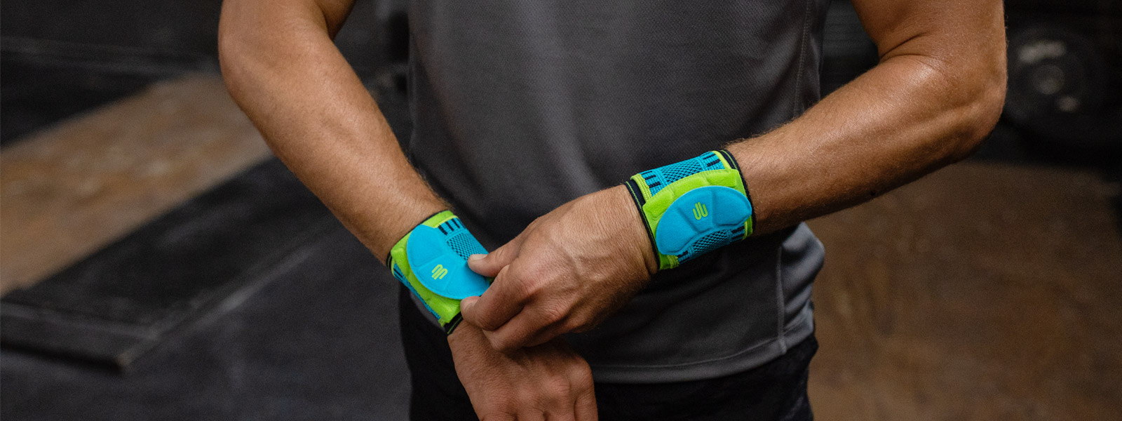 S'assoit comme tu le veux : le Sports Wrist Strap avec sangle réglable individuellement Homme dans une salle de fitness ajuste l'un de ses bandages de poignet