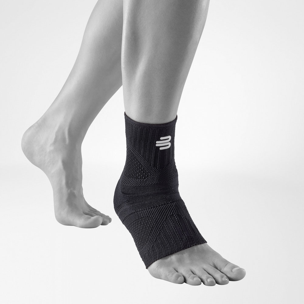 Vue de face inclinée de la chevillère allblack Vue complète de face de l'Ankle Support Dynamic en couleur allblack sur une jambe stylisée grise