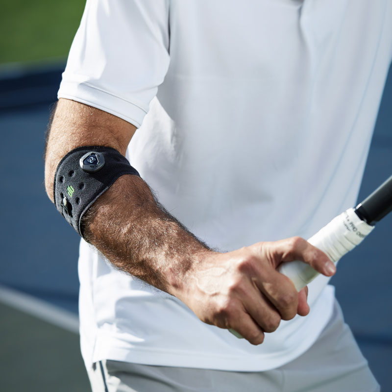 Le Sports Elbow Strap prévient le tennis elbow Avant-bras d'un joueur de tennis avec un bandage au coude, tenant la raquette en main