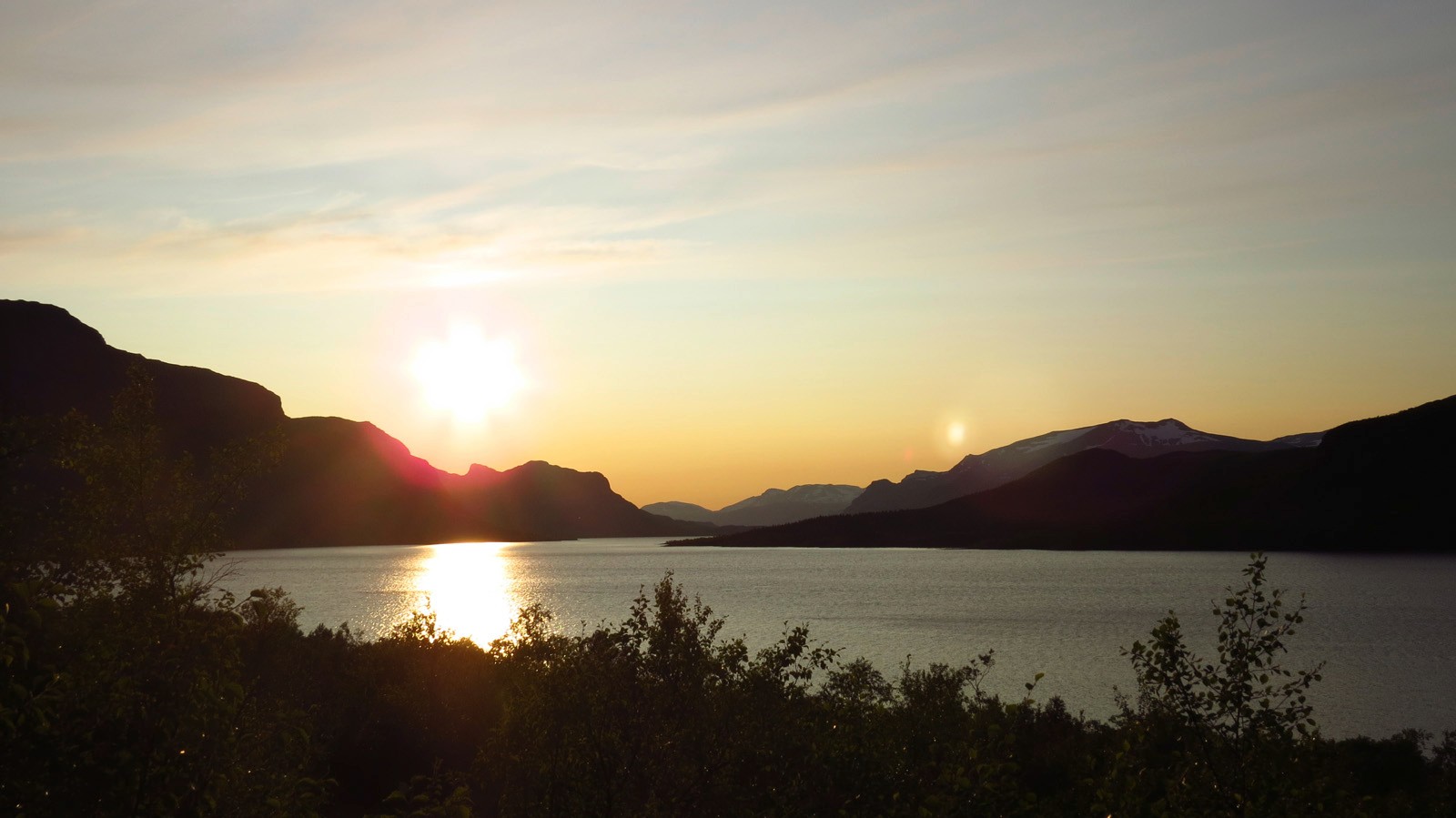 Panorama d'un lac avec des montagnes au coucher du soleil