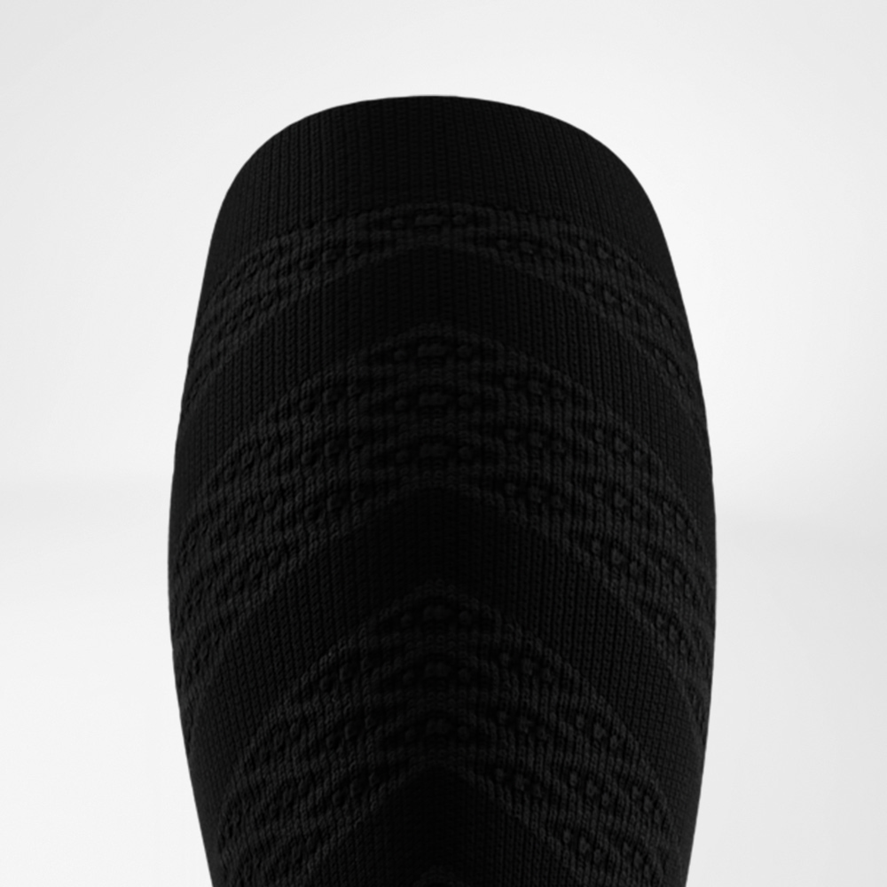 Black Edition – Stärke mit Stil Obere Ansicht eines schwarzen Compression Sleeves mit markantem Zickzack-Strickmuster. Die Struktur bietet Stabilität und eine kraftvolle, sportliche Optik.