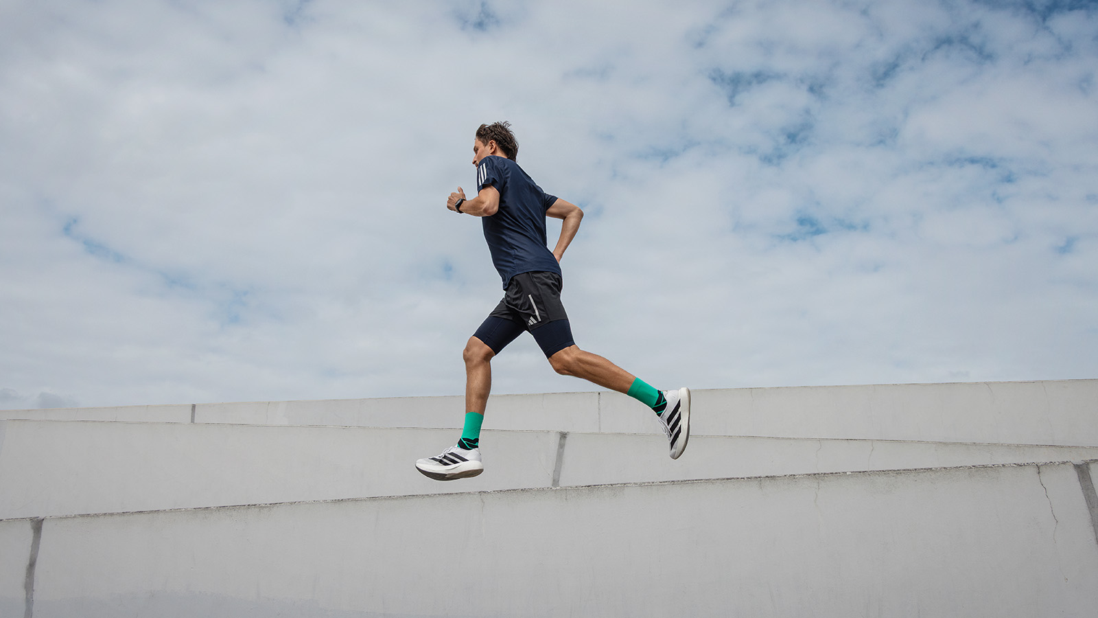 Chaussettes de course pour hommes: Utilité et offre Homme court dans une ville à côté d'un musée moderne