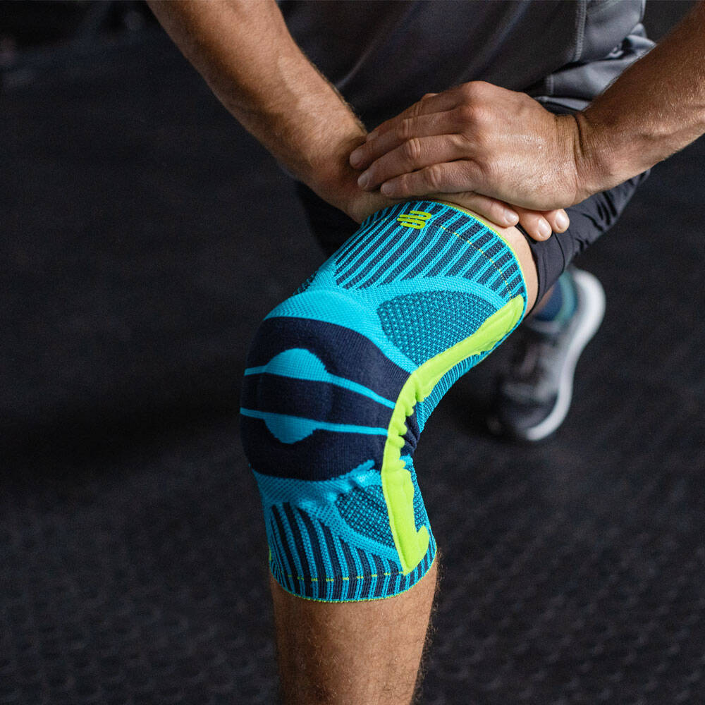 Sports Knee Support pour les squats - Entraînement de fitness Homme plie son genou en portant une Sports Knee Support