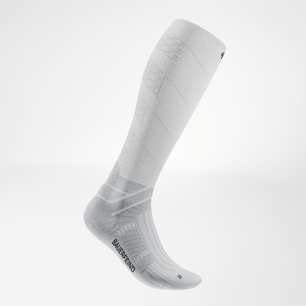 Die Passform sitzt – auch bei intensiven Runs. Seitenansicht der weißen Run Performance Socks Long, rechte Socke mit sichtbaren Kompressionszonen und markanter Struktur am Spann.
