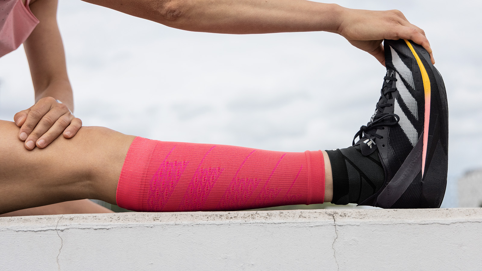 Étirement du mollet avec des chaussettes de course longues en rose
