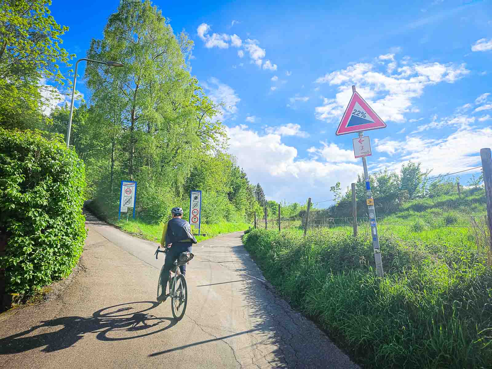 Cycliste devant une forte pente de route Un cycliste monte une pente très raide lors du Race around the Netherlands.