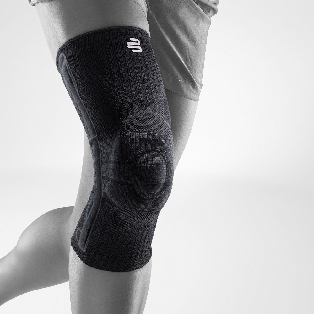 Vue complète d'une genouillère noire pour le sport sur une jambe grise stylisée