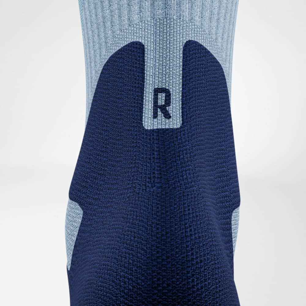 Chaussettes de randonnée en mérinos mi-longues bleu clair détail zone de confort d'Achilles Prise de vue détaillée de la zone de confort d'Achilles des chaussettes de randonnée mi-longues en mérinos bleu clair