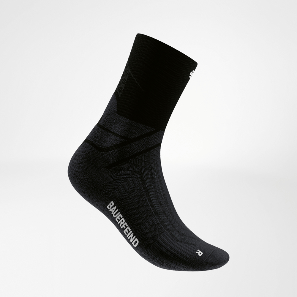 Schwarz, stark, kompromisslos – dein Lauf, deine Power! Seitliche Ansicht einer schwarzen Midcut-Laufsocke von Bauerfeind mit kontrastierendem Logo und ergonomischer Passform. Die Socke ist auf Stabilität und Halt in schnellen Läufen ausgelegt und kombiniert Performance mit schlichtem Style.