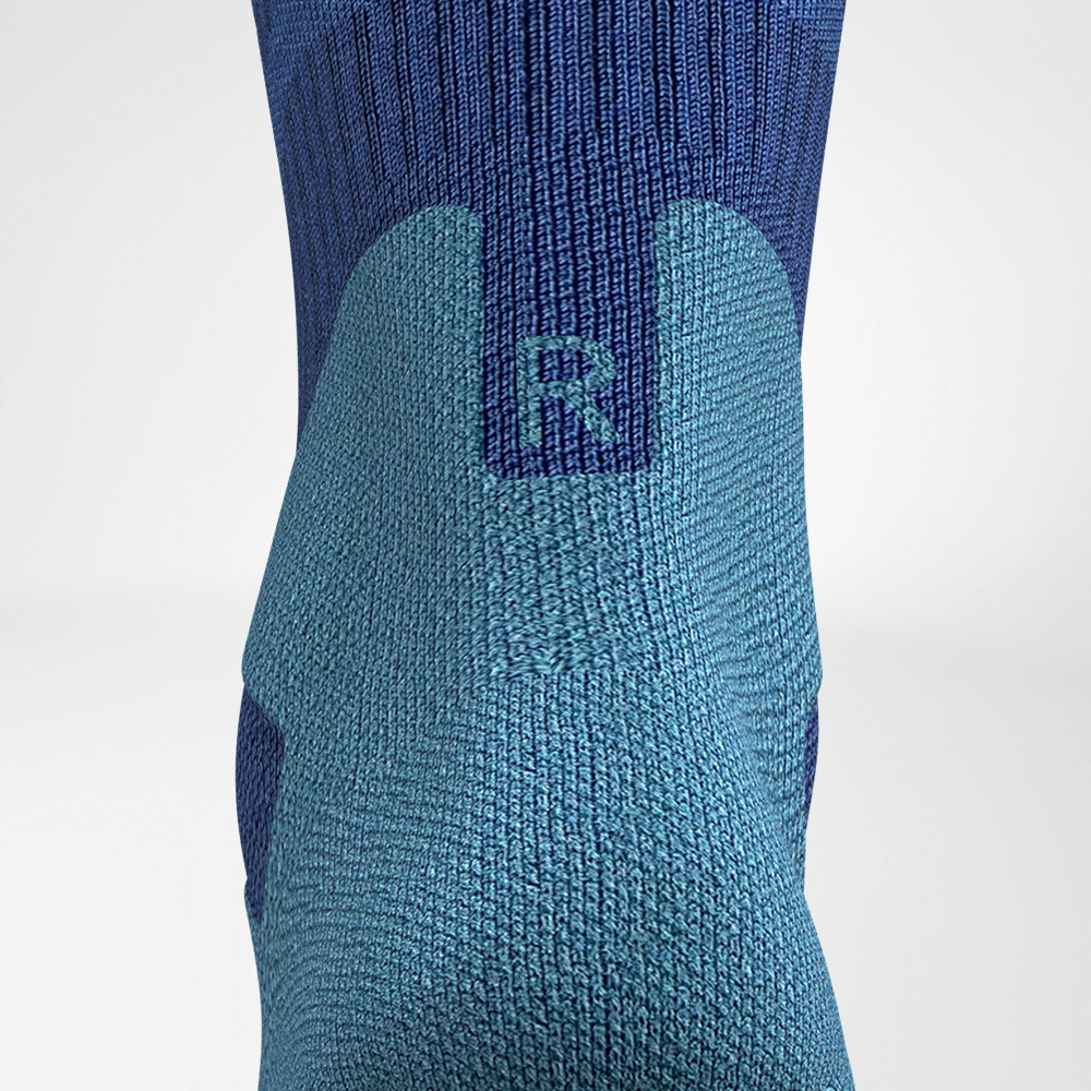 Chaussettes de randonnée mi-longues en mérinos bleu clair Détail confort Achilles Détail de la zone de confort d'Achilles des chaussettes de randonnée mi-longues en mérinos bleu foncé