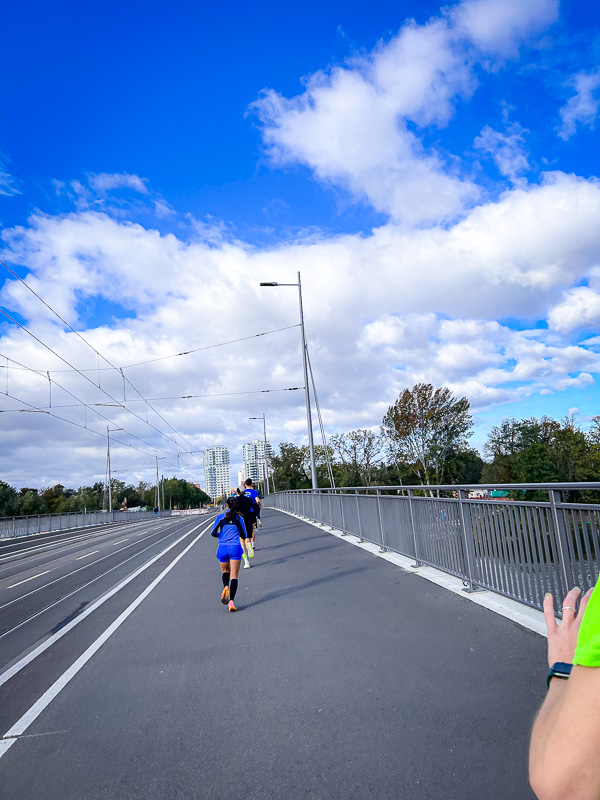 Starker Gegenwind und fehlende Gruppe beim Halbmarathon Läufer auf einer Brücke kämpfen gegen starken Gegenwind ohne die Hilfe einer schützenden Gruppe beim Halbmarathon.