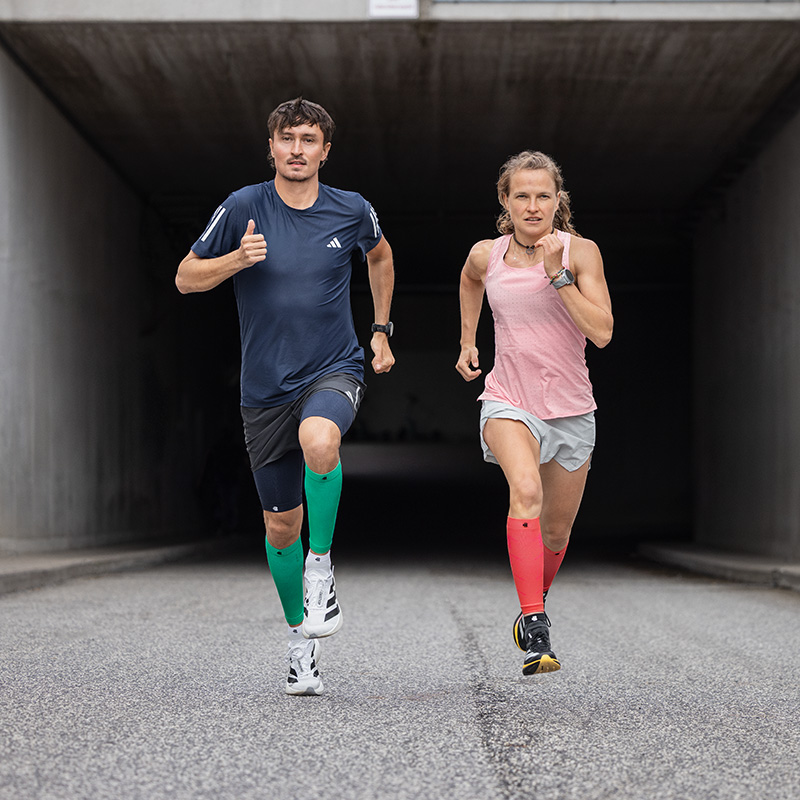 Envie d'un petit sprint dans les escaliers ? Avec de petits obstacles, tu rends ton entraînement encore plus varié et meilleur Vue aérienne : Un homme et deux femmes en tenues de course montent un escalier dans une vieille ville avec des graffitis sur les murs