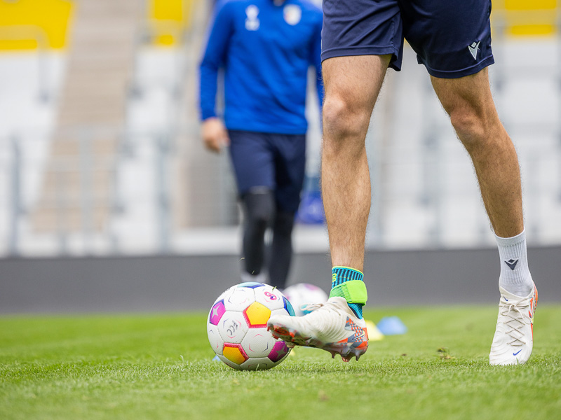 Joueur du FC Carl Zeiss Jena dans le stade dribblant avec un bandage au pied