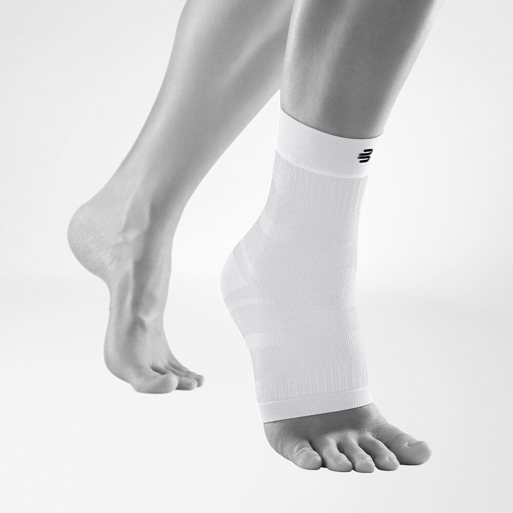 Compression Ankle Support blanc vue de face en biais Vue complète de la Compression Ankle Support blanche sur une jambe grise stylisée