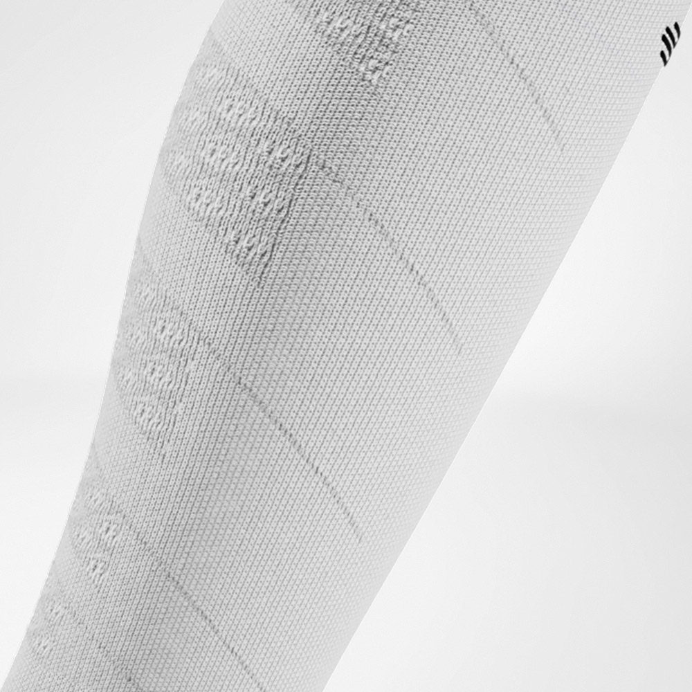 Weiß und stark – minimalistisch, aber voller Energie Detailaufnahme eines weißen Compression Sleeves mit markanter Strickstruktur. Das Material bietet eine klare, sportliche Optik und gezielte Unterstützung für die Waden.