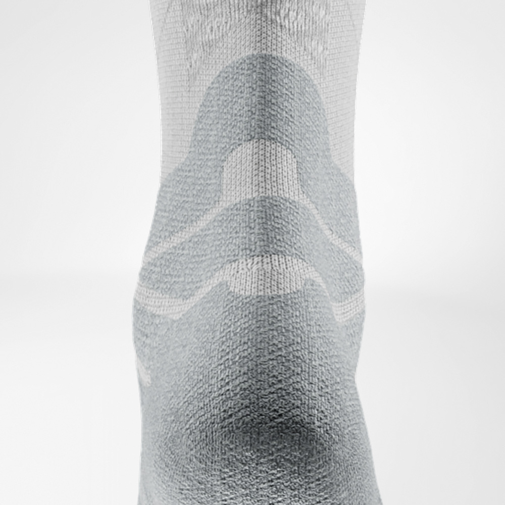 Schlicht in Weiß, stark im Detail. Detailaufnahme der weißen Run Performance Midcut Socke, Rückansicht mit betontem Strickmuster am Schaft und verstärktem Bereich über der Achillessehne.