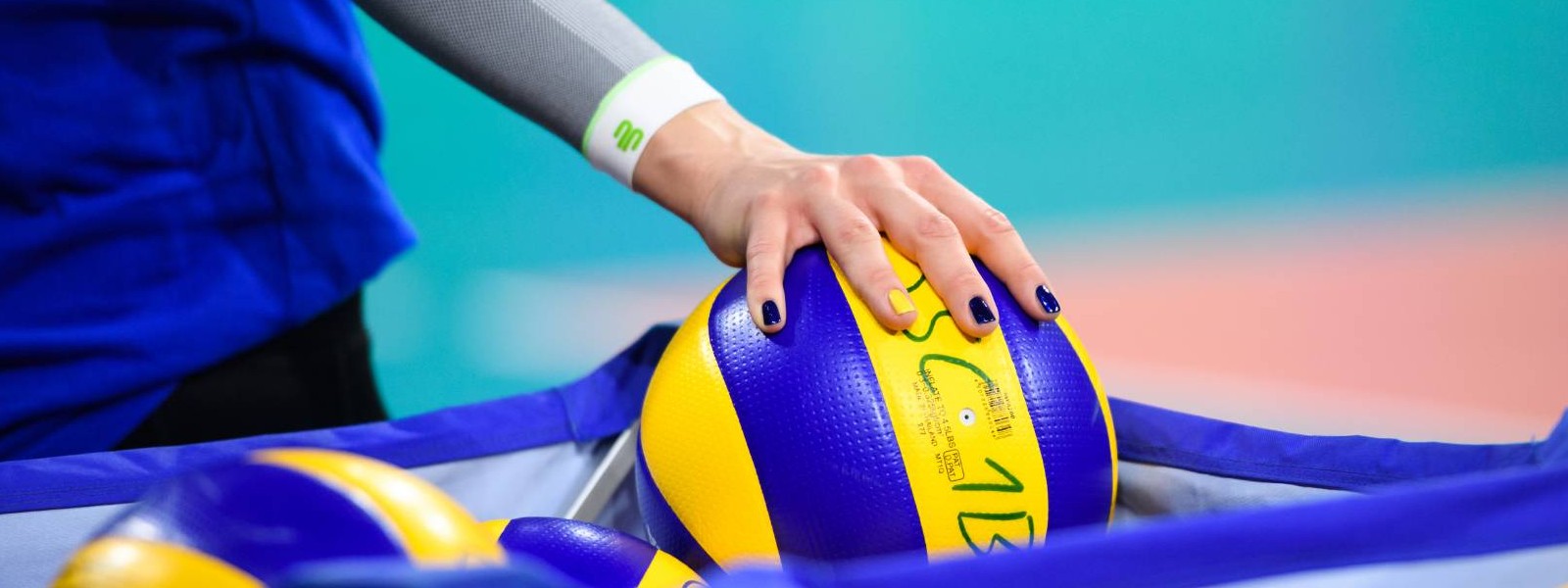 Manchons lors du volley-ball Joueuse de volley-ball avec des manchons blancs attrapant un ballon de volley-ball