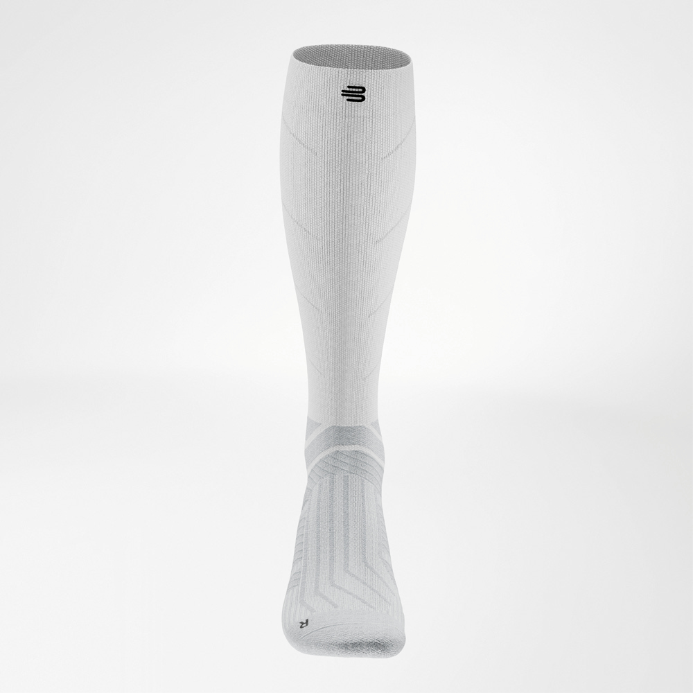 Unterstützt deinen Lauf – vom Fuß bis zur Wade. Frontalansicht der weißen Run Performance Socks Long mit symmetrischem Design und betonten Kompressionsbereichen.