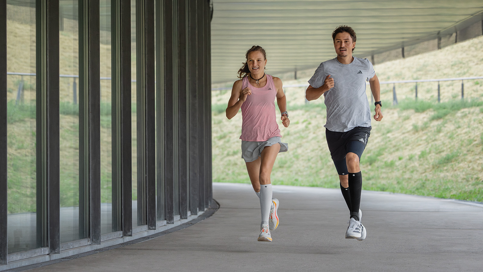 Accélérer et s'amuser : avec nos Run Perfomance Compression Socks Coureuse avec des chaussettes de course blanches et roses court à côté d'un mur moderne